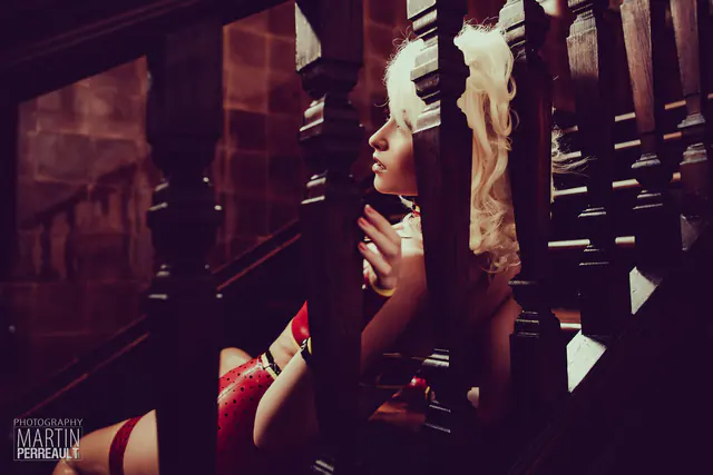 A blonde model seen through the banisters of a staircase