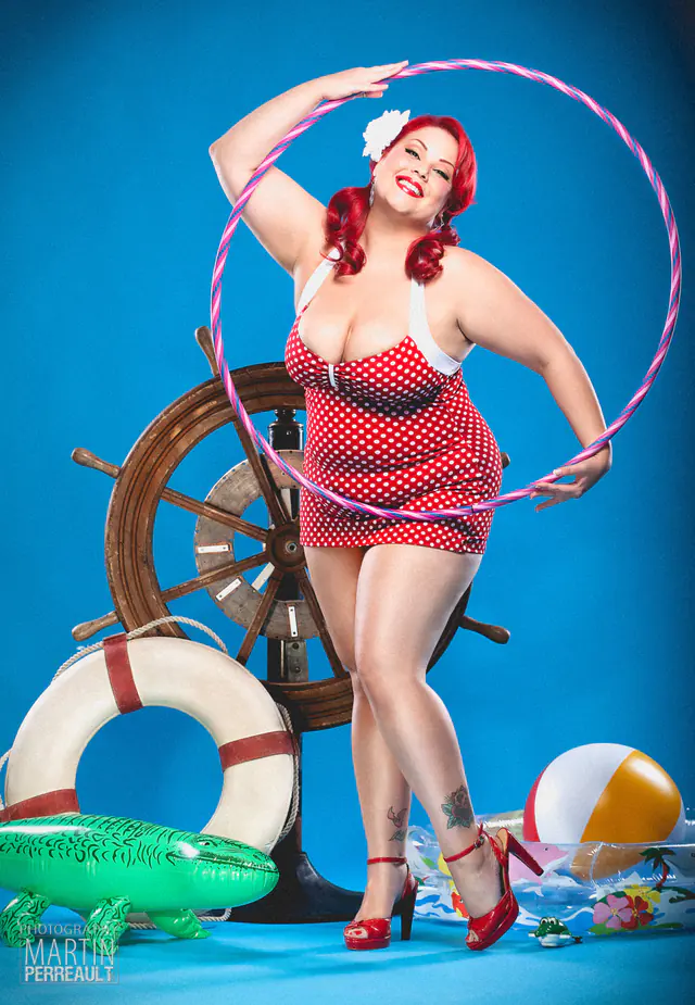A pin-up model in a polka-dot dress with a hula hoop and a ship’s wheel