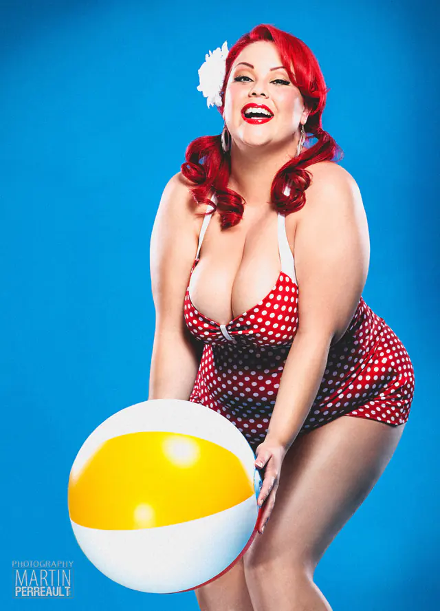 A pin-up model in a polka-dot swimsuit with a beach ball