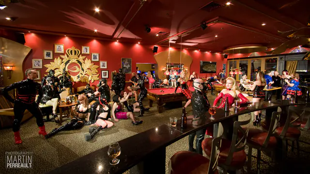 A crowd in latex fashion in a pool hall, from the Latex Land project