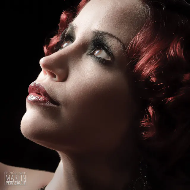 A red-haired woman in profile, looking up