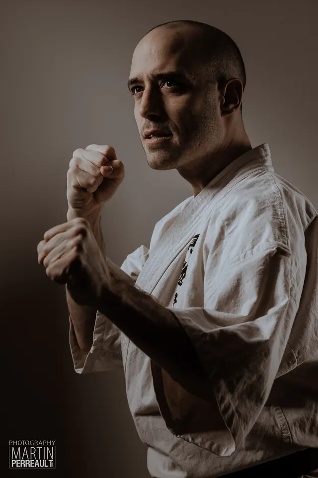 A martial artist in a white gi, fists raised