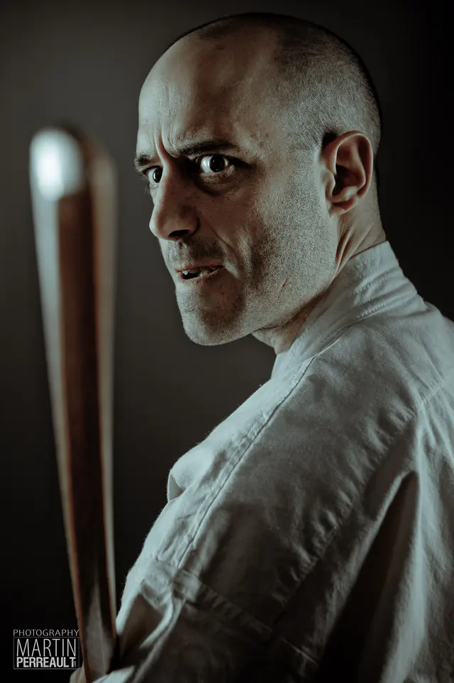 A martial artist holding a wooden staff
