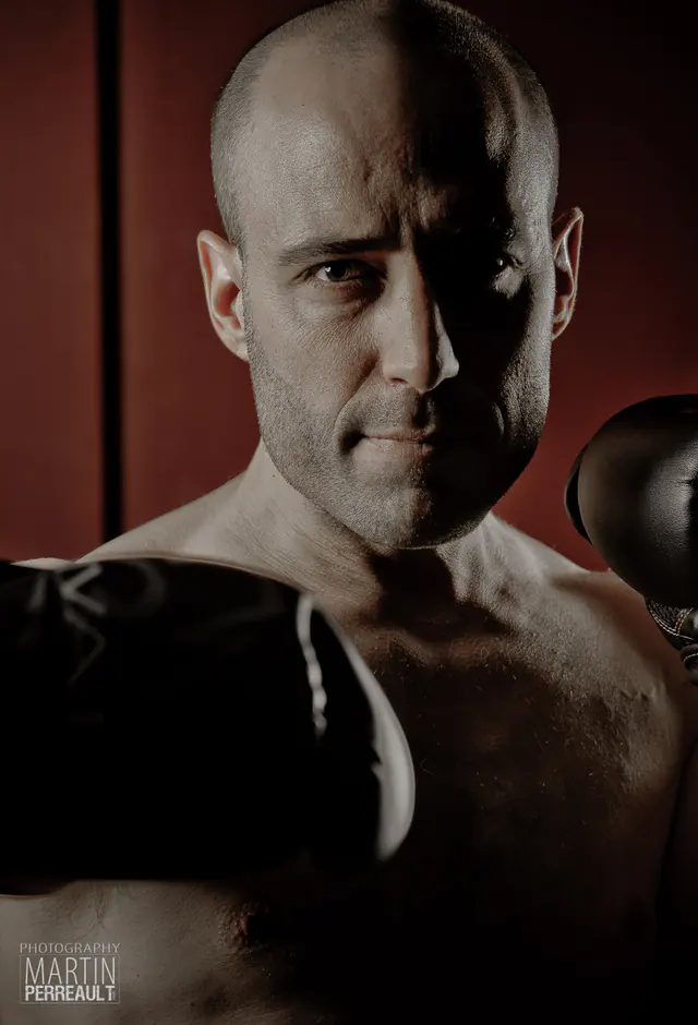 A boxer in gloves under red light