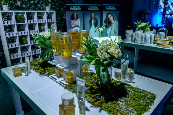 Haircare products and white flowers on a moss-covered table