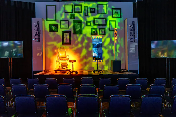 A conference stage lit with green patterns and picture frames