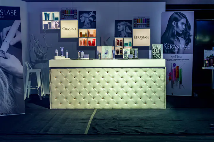 A Kérastase counter with tufted white panels