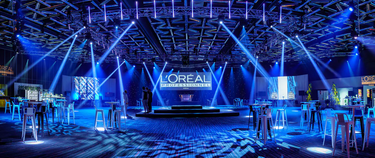 The main hall of L’Oréal Montreal Unplugged under blue stage lights, with the L’Oréal stage at the centre