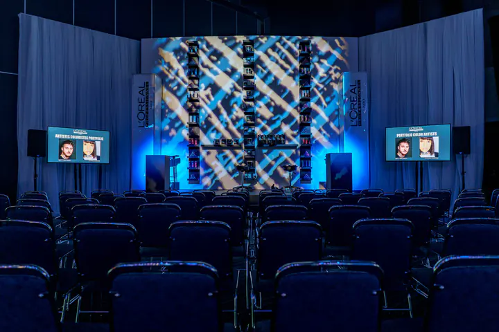 A conference room with patterned blue light on the stage wall