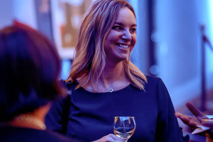 A smiling guest holding a glass of wine