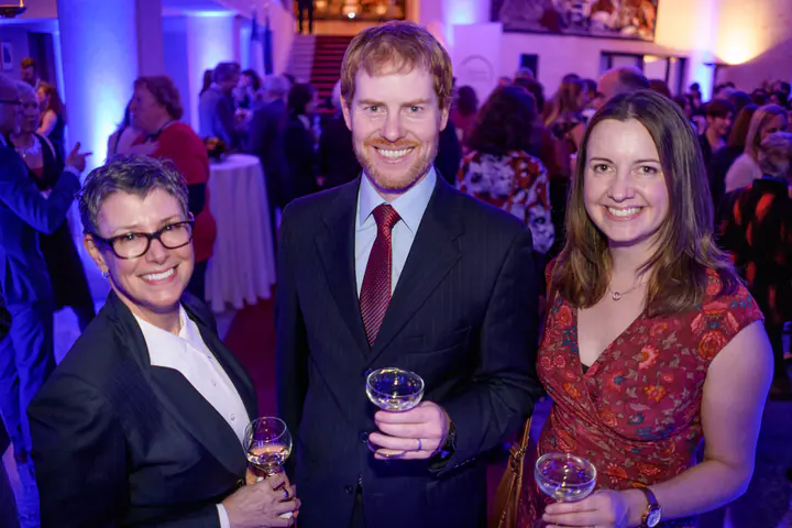 Three guests with their drinks in the reception hall