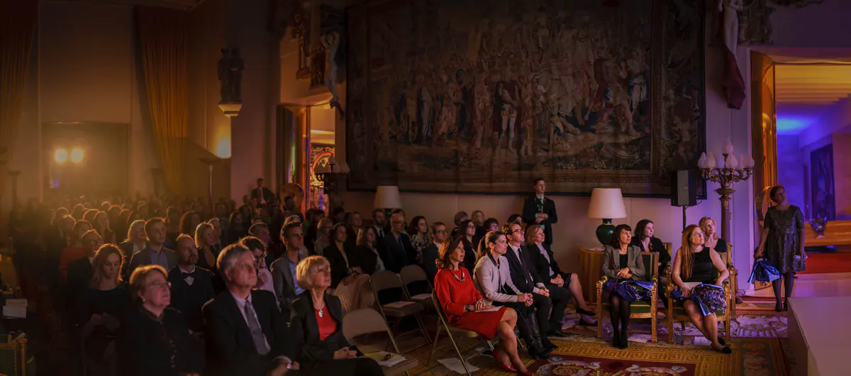The awards ceremony in a hall hung with tapestries